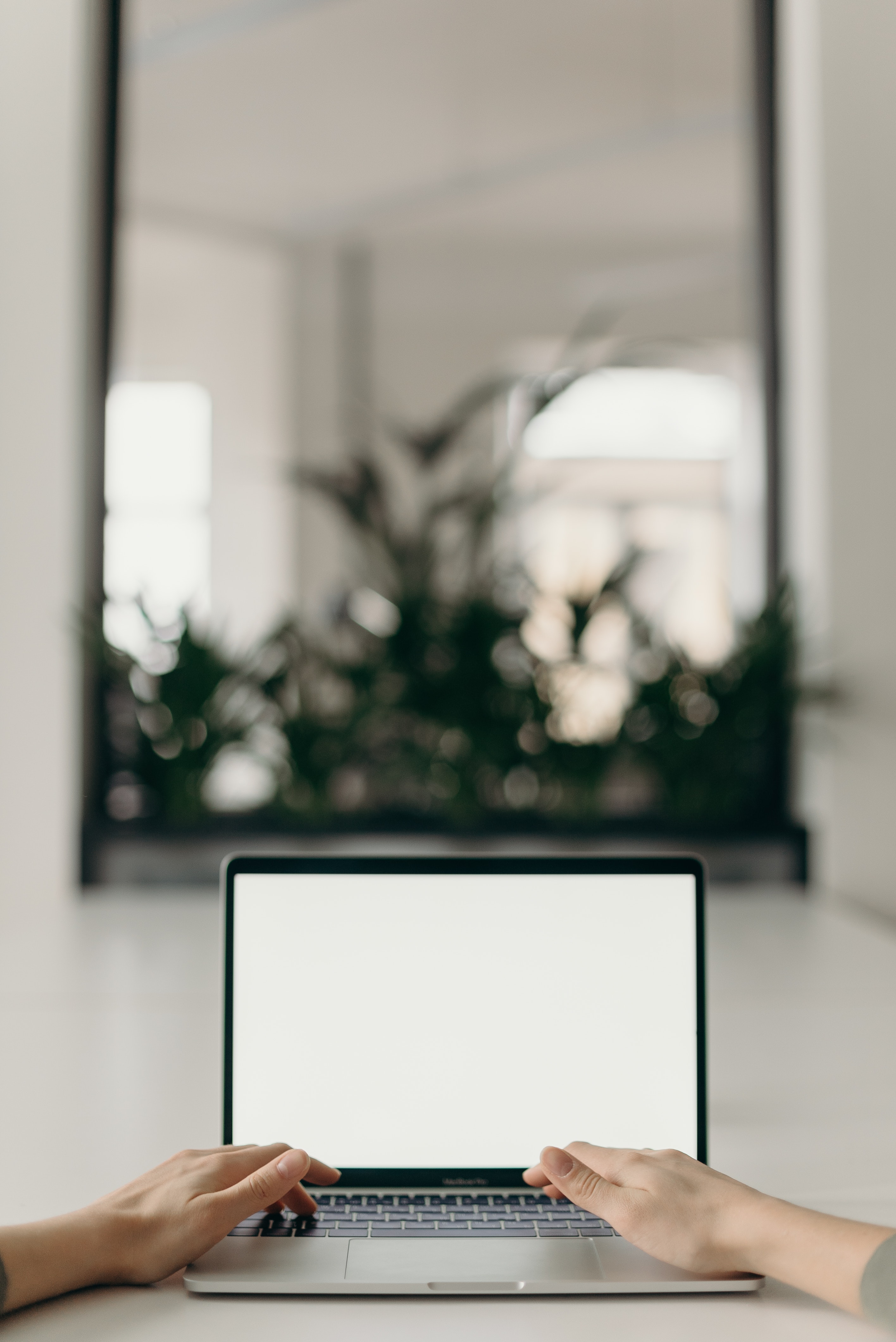 Photo of two hands typing on a laptop keyboard, searching for a job online.