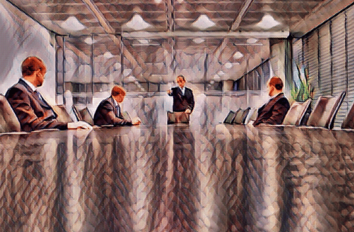 Board room table with three men seated and one man standing waving his arm